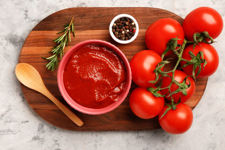 Bowl with tasty tomato paste and fresh vegetables on grunge backgroundの写真素材
