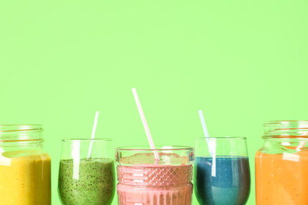 Glasses of colorful smoothie on green backgroundの写真素材