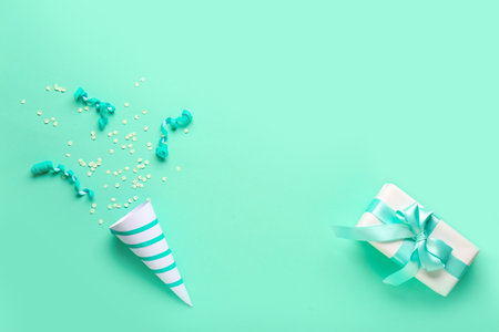 Frame made of party cone with serpentine, confetti and gift on green backgroundの写真素材