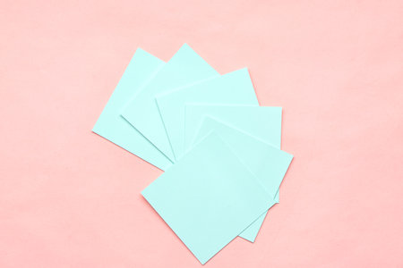 Blue sticky notes on pink backgroundの写真素材