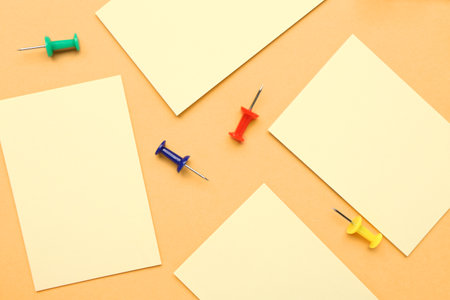 Sticky notes and colorful pins on yellow backgroundの写真素材
