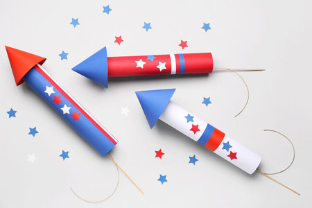 Firework rockets with stars for Independence Day on light background
