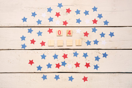 Date 4 JULY with stars on white wooden background