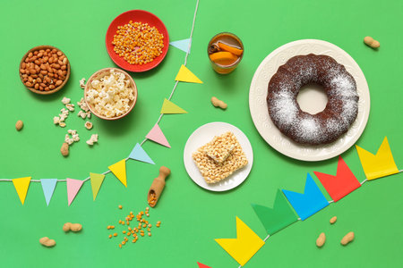 Traditional food with flags for Festa Junina (June Festival) on green background