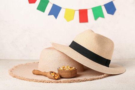 Scoop with bowl of corn and straw hats on white table. Festa Junina (June Festival) celebration