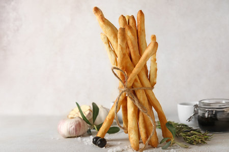 Bunch of tasty Italian Grissini on light background