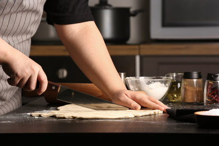 Woman preparing Italian Grissini at table in kitchen, closeup
