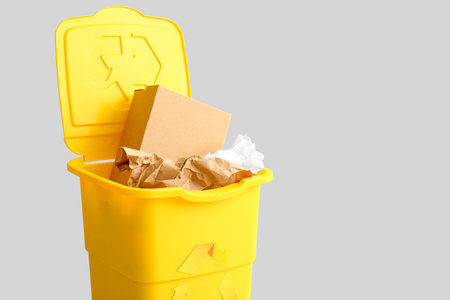 Container for garbage with paper on light background. Recycling conceptの写真素材