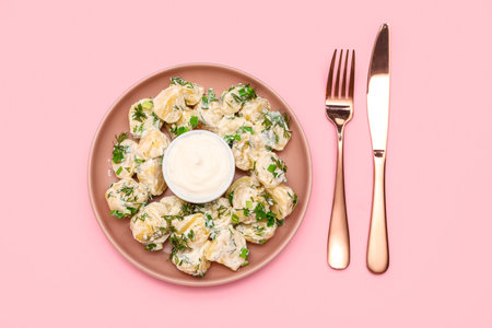 Plate of tasty Potato Salad with greens on pink backgroundの写真素材