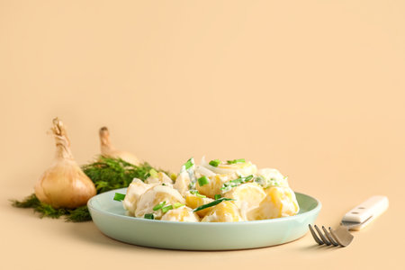 Plate of tasty Potato Salad with greens on yellow backgroundの写真素材