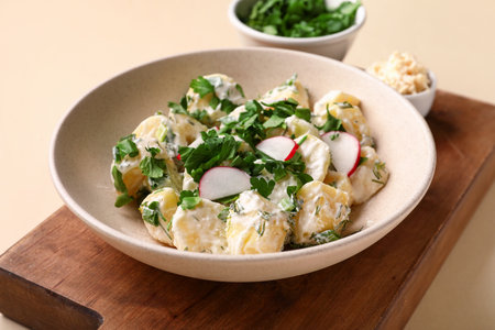 Plate of tasty Potato Salad with greens on yellow background, closeupの写真素材