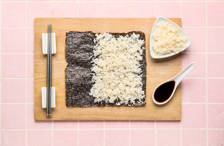 Wooden board of nori with rice and sauce on pink tile backgroundの写真素材