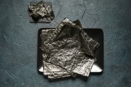 Plate with nori sheets on dark color background