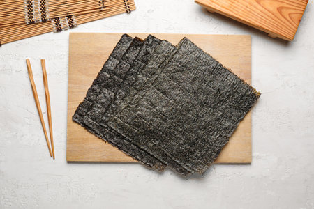 Wooden board with nori sheets on light backgroundの写真素材