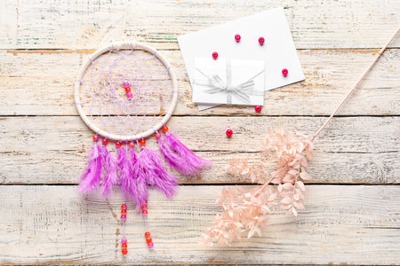 Dream catcher with envelope and plant branch on white wooden backgroundの写真素材