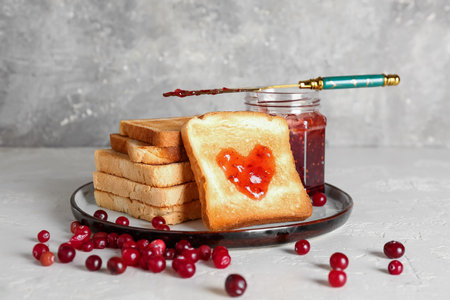Plate of tasty toasts with cranberry jam on tableの写真素材