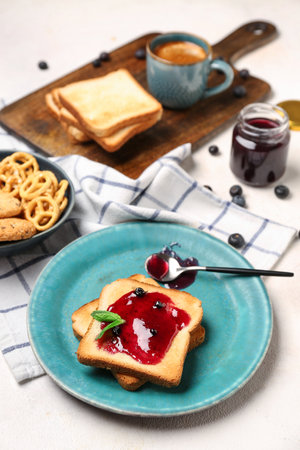 Plate of tasty toasts with blueberry jam on light backgroundの写真素材