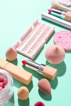 Decorative cosmetics with makeup sponges on green background, closeupの写真素材