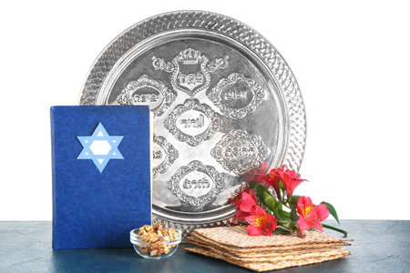 Torah, Passover Seder plate, flatbread matza, walnuts and alstroemeria flowers on table against...