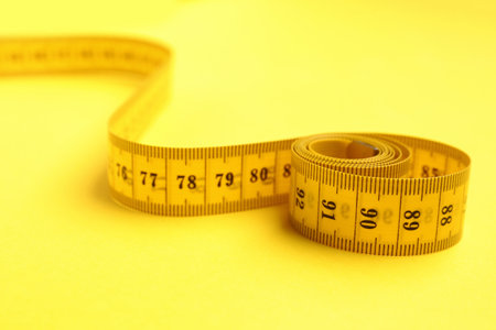 New measuring tape on yellow background, closeupの写真素材