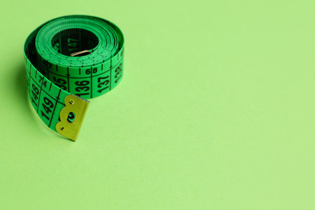 New measuring tape on green backgroundの写真素材