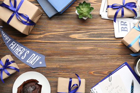 Frame made of gifts for Father's Day celebration, card, houseplant and muffin on wooden backgroundの写真素材