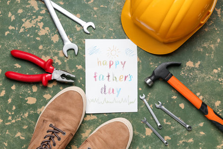Card with text HAPPY FATHER'S DAY, shoes and construction tools on grunge backgroundの写真素材