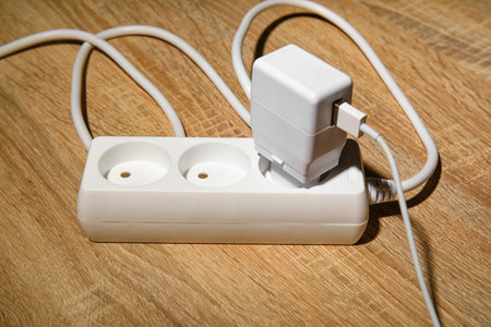 Electric extension cord with plug on wooden floorの写真素材