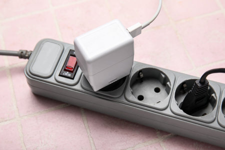 Electric extension cord with plugs on pink tile backgroundの写真素材