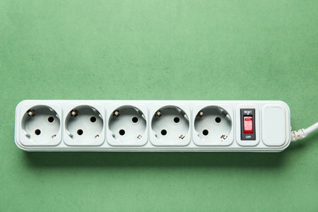 Electric extension cord on green background