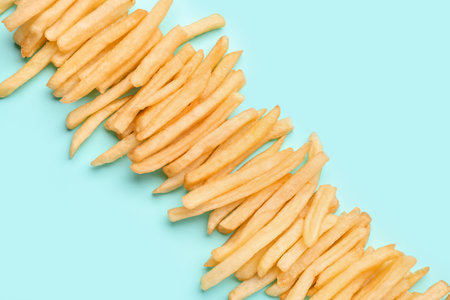 Tasty french fries on light blue backgroundの写真素材