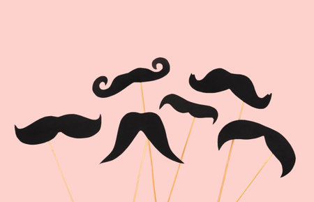 Wooden sticks with different paper mustaches on pink backgroundの写真素材