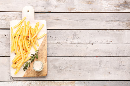 Board with tasty french fries and salt on wooden backgroundの写真素材