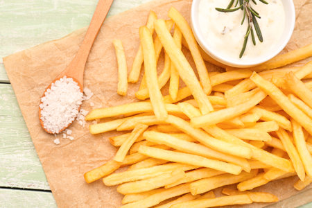 Tasty french fries, mayonnaise and salt on green wooden backgroundの写真素材