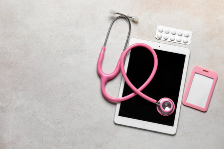 Stethoscope, tablet computer, badge and pills on light backgroundの写真素材