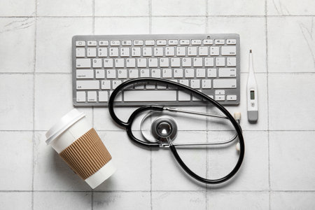 Stethoscope, pc keyboard and coffee on light backgroundの写真素材