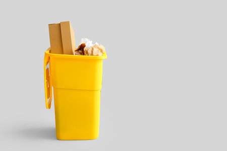 Container for garbage with paper on light background. Recycling conceptの写真素材