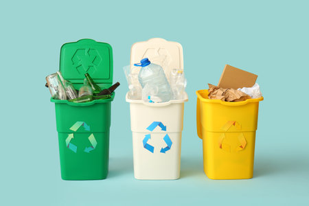 Containers with different types of garbage on light blue background. Recycling conceptの写真素材