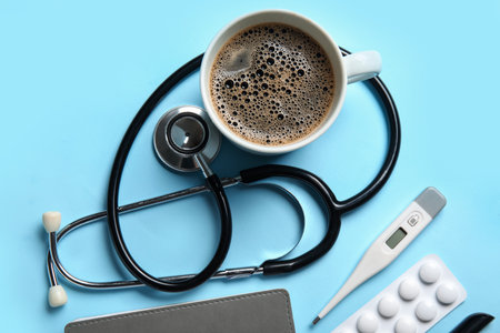 Stethoscope, thermometer, coffee and pills on blue backgroundの写真素材