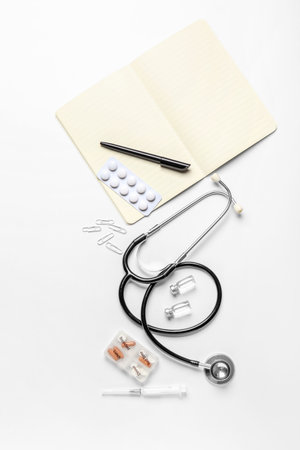 Stethoscope, notebook and drugs on white backgroundの写真素材