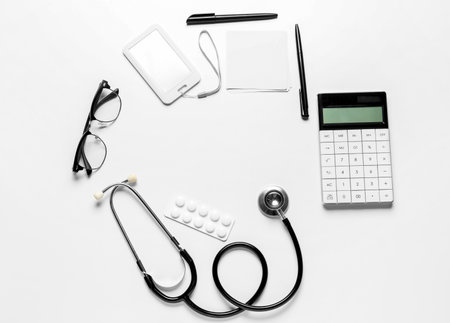Frame made of stethoscope, calculator, badge, glasses and pills on white backgroundの写真素材