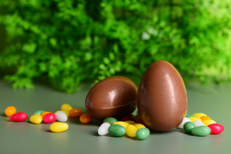 Chocolate Easter eggs and candies on green backgroundの写真素材