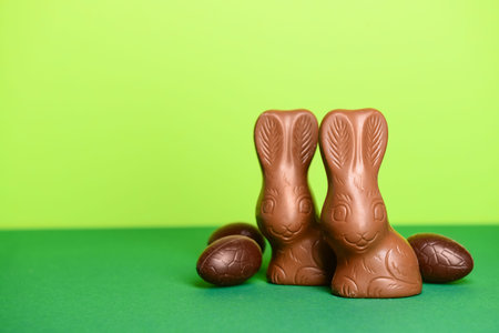Chocolate bunnies and Easter eggs on green background