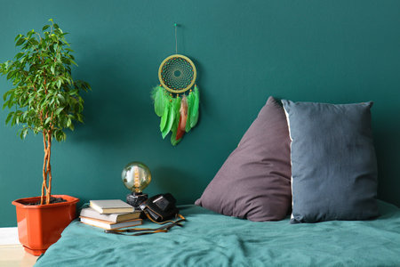 Dream catcher hanging on green wall in bedroomの写真素材