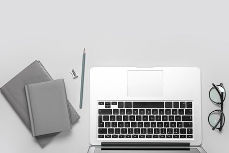 Composition with laptop, notepad and eyeglasses on gray backgroundの写真素材