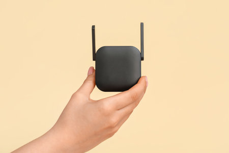 Woman holding black WiFi repeater on gray backgroundの写真素材
