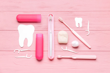 Composition with dental floss, toothpicks and brushes on pink wooden backgroundの写真素材