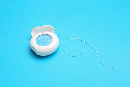 Case with dental floss on blue backgroundの写真素材