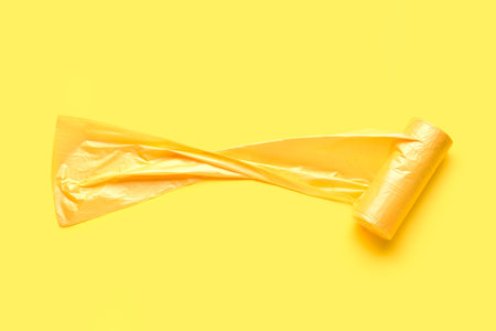 Roll of garbage bags on yellow backgroundの写真素材
