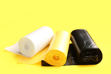 Different rolls of garbage bags on yellow backgroundの写真素材